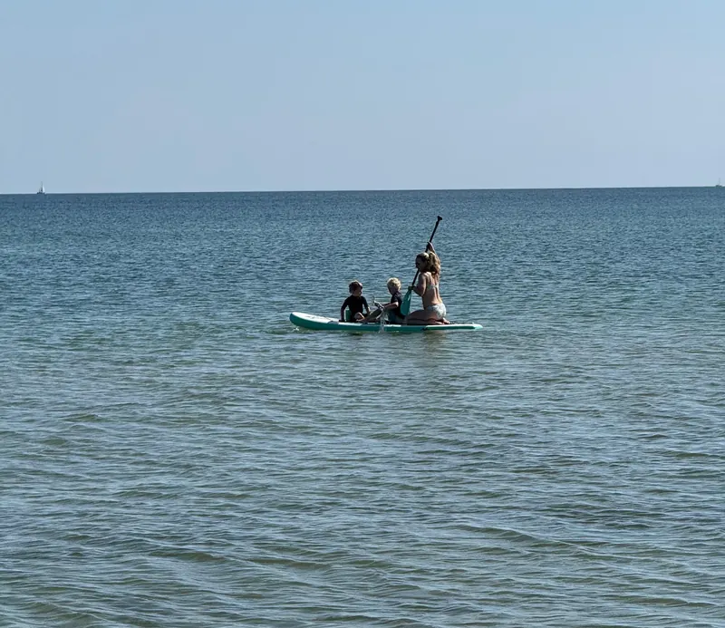 Familie auf einem Stand-up-Paddle-Board auf der ruhigen Ostsee